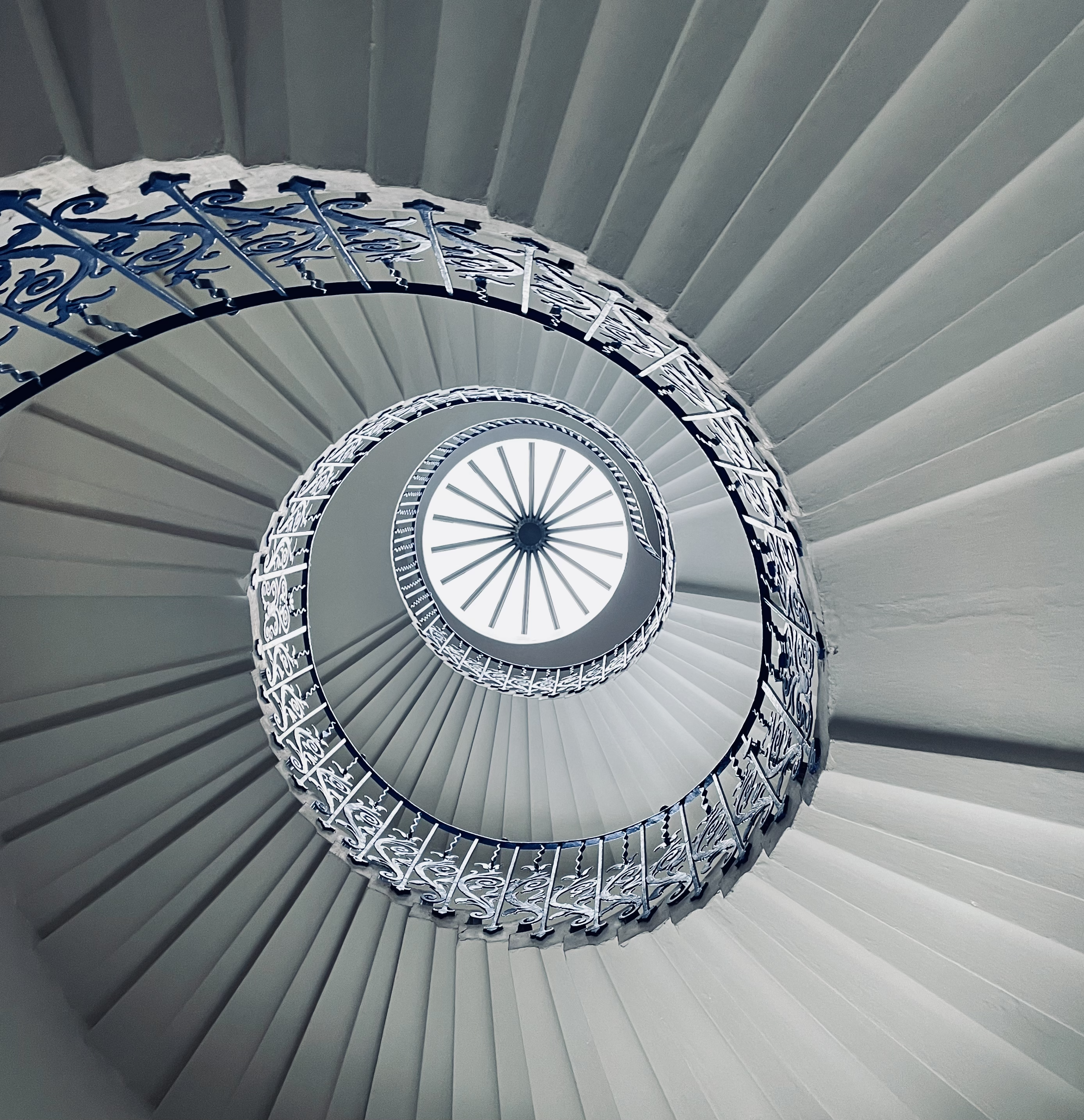 Looking up a blue and white spiral staircase from the Queen's House in Greenwich