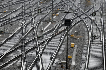 Image of a train switching yard with multiple tracks and many switches. 